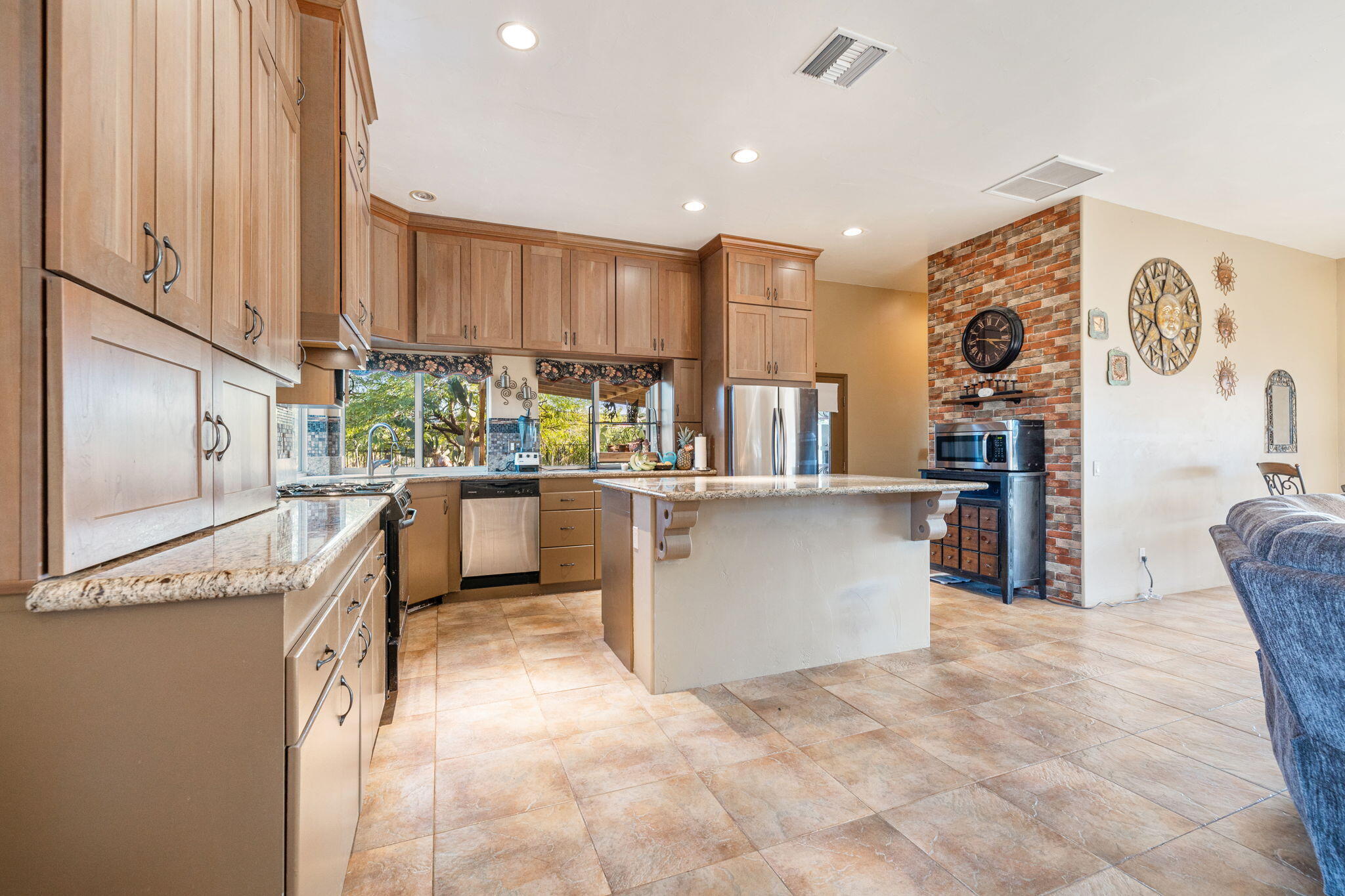22950 Henry Road Desert Hot Springs, CA 92241 - Photo 11 of 68 a kitchen with stainless steel appliances kitchen island granite countertop a refrigerator a stove and a sink with cabinets
