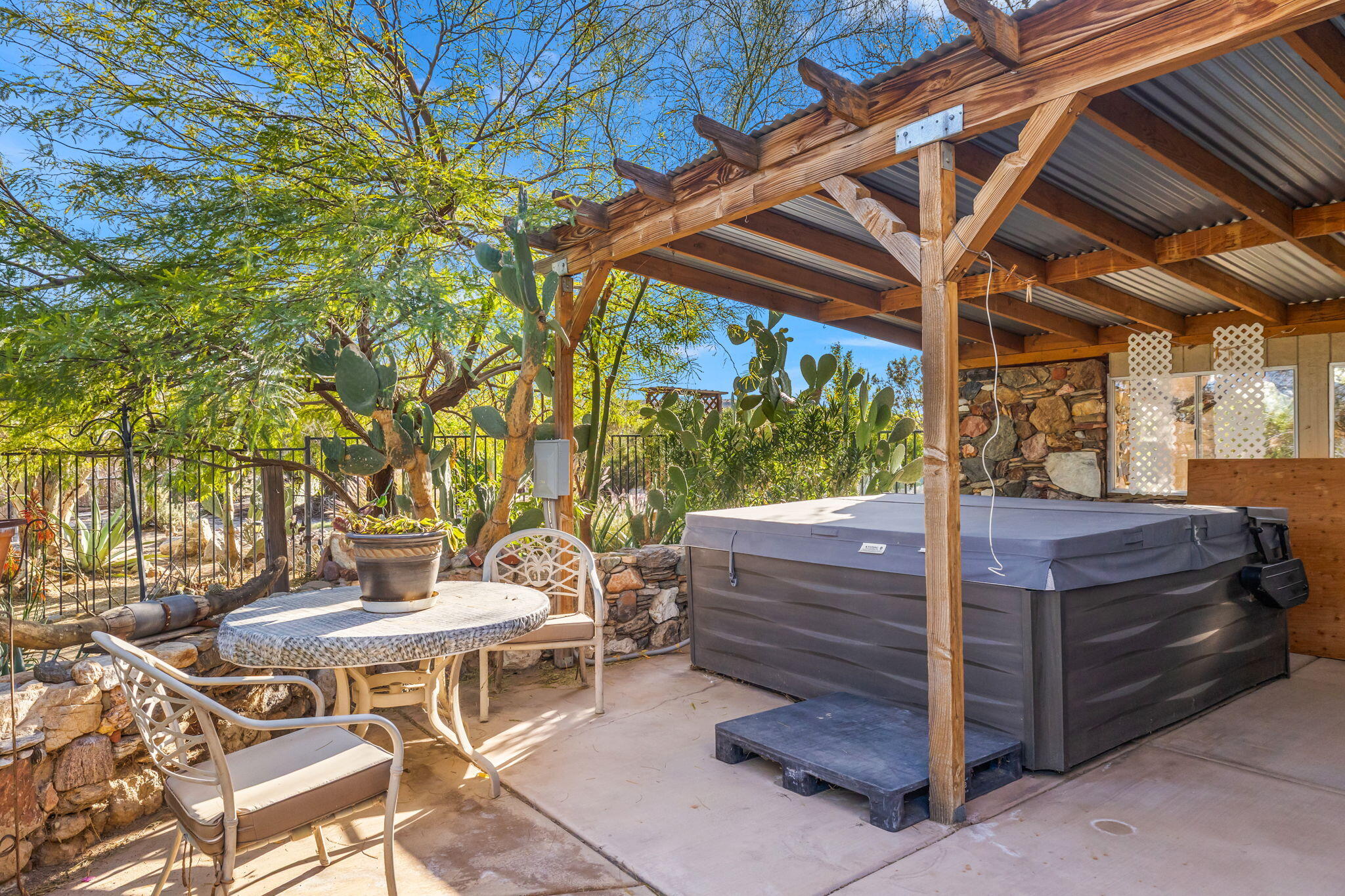 22950 Henry Road Desert Hot Springs, CA 92241 - Photo 31 of 68 a view of a patio with table and chairs with wooden floor and fence