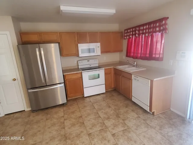 a kitchen with stainless steel appliances granite countertop a refrigerator a stove a sink and a microwave