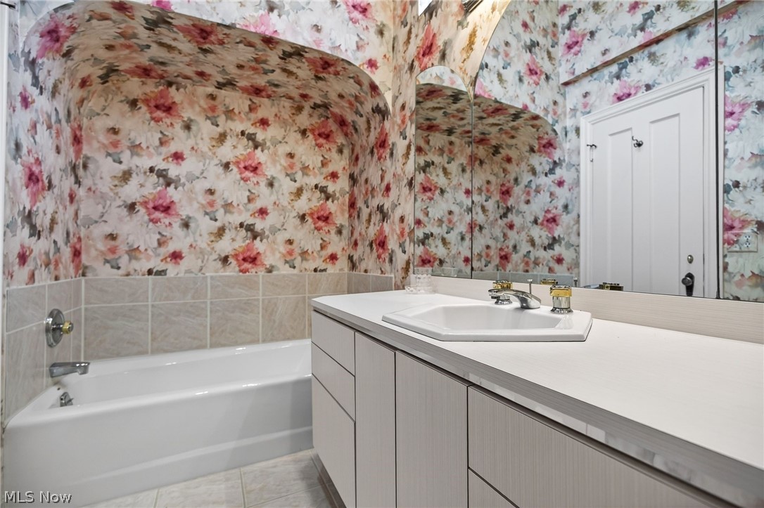 3498 Bainbridge Road Cleveland Heights, OH 44118 - Photo 29 of 50 Bathroom featuring wallpapered walls, a garden tub, vanity, and light tile patterned flooring
