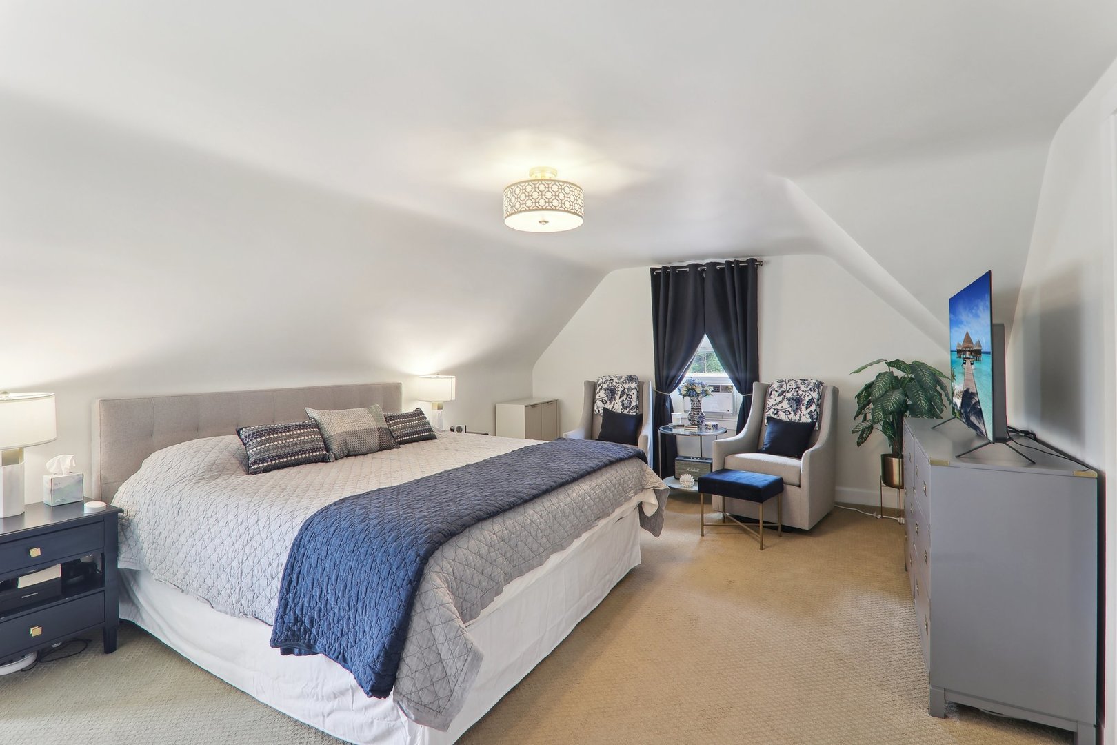 5853 North Central Avenue Chicago, IL 60646 - Photo 15 of 31 a spacious bedroom with a bed and a flat tv screen on dresser