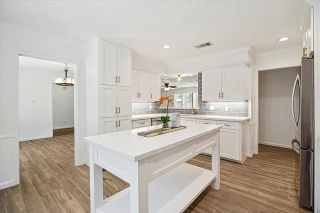 a kitchen with white cabinets and stainless steel appliances