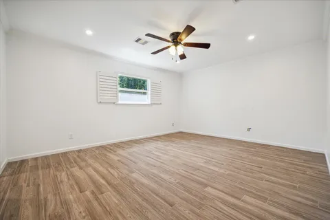 a view of a room with wooden floor and a ceiling fan