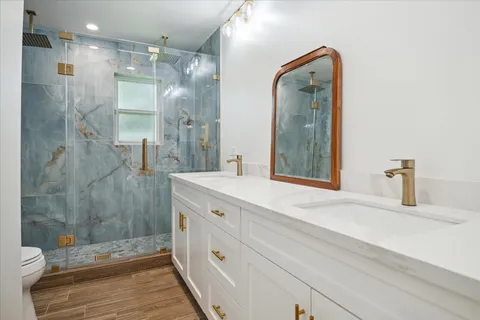 a bathroom with a double vanity sink mirror and shower
