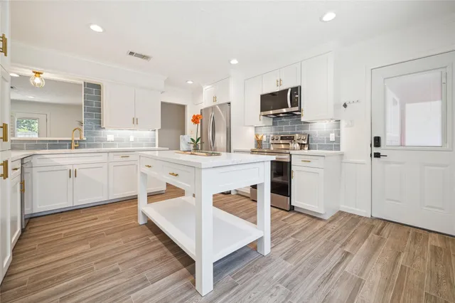 a kitchen with white cabinets stainless steel appliances and sink