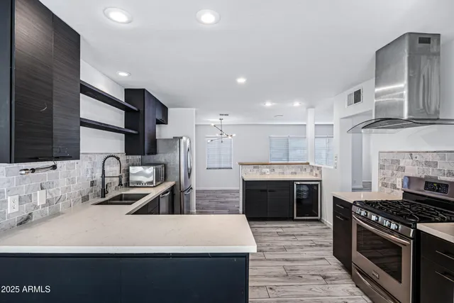 a large kitchen with stainless steel appliances granite countertop a stove refrigerator and cabinets