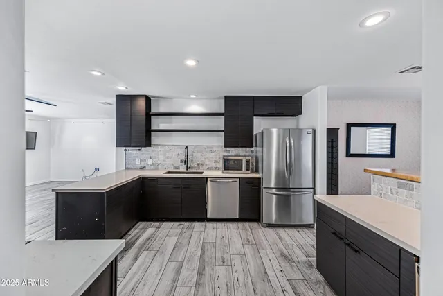 a kitchen with stainless steel appliances granite countertop a sink stove and refrigerator