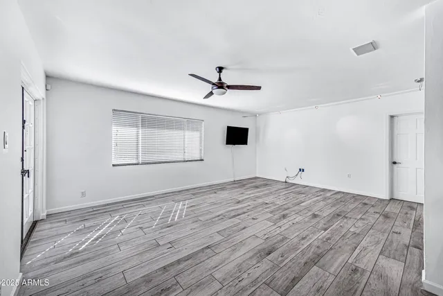a view of a livingroom with wooden floor and a ceiling fan
