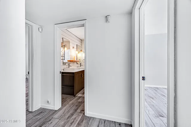 a view of a hallway to an empty room and wooden floor