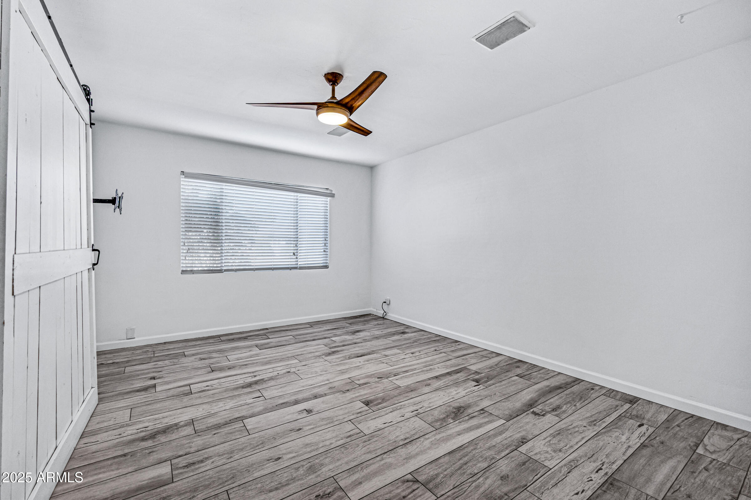 6829 East Almeria Road Scottsdale, AZ 85257 - Photo 17 of 35 a view of empty room with wooden floor and fan