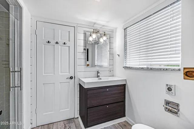 a bathroom with a sink a toilet and a window