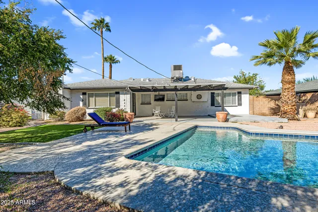 a view of a house with backyard and sitting area
