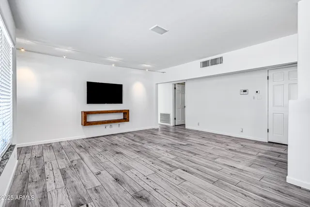a view of room with wooden floor and flat screen tv