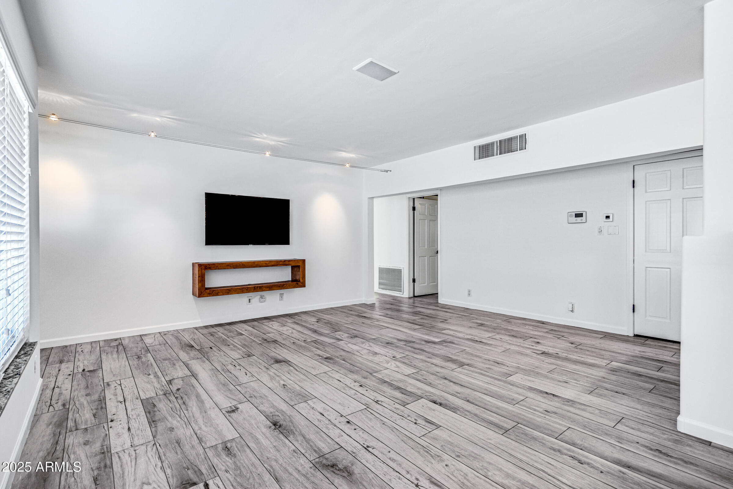 6829 East Almeria Road Scottsdale, AZ 85257 - Photo 5 of 35 a view of room with wooden floor and flat screen tv