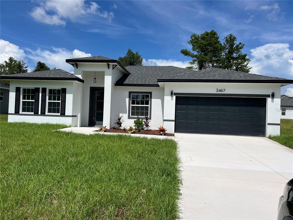 2467 Southwest 170th Loop Ocala, FL 34473 - Photo 1 of 1 a front view of a house with a garden and plants