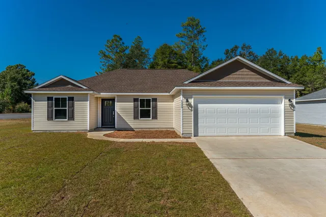 a front view of a house with a yard and garage