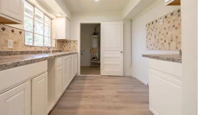a view of a kitchen with cabinets and wooden floor
