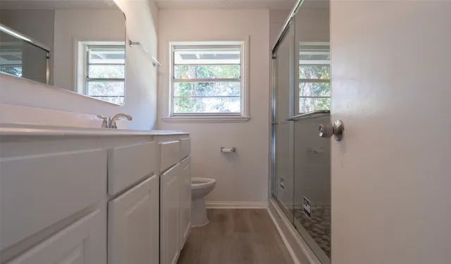 a bathroom with a sink a toilet and a window