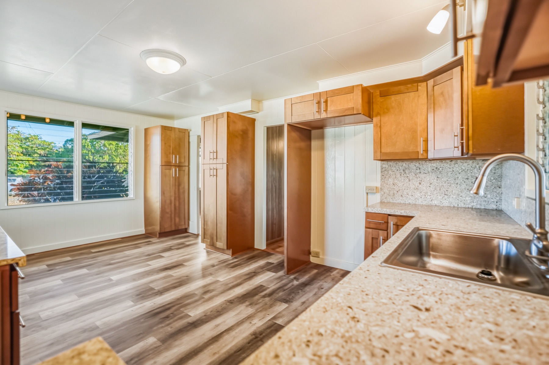 7976 Elepaio Road Kekaha, HI 96752 - Photo 26 of 30 a kitchen with granite countertop a sink and a stove top oven