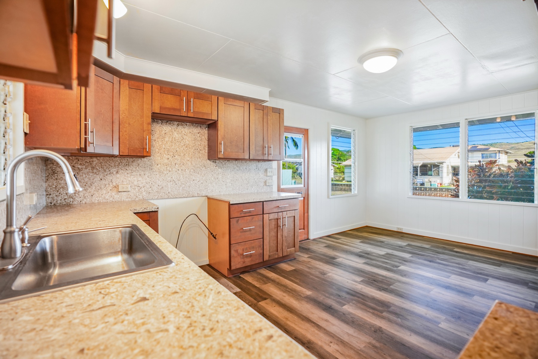 7976 Elepaio Road Kekaha, HI 96752 - Photo 6 of 30 a kitchen with a sink wooden cabinets and a window