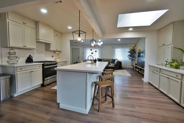 a kitchen with white cabinets and appliances