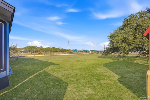 a view of yard with swimming pool and trees in the background