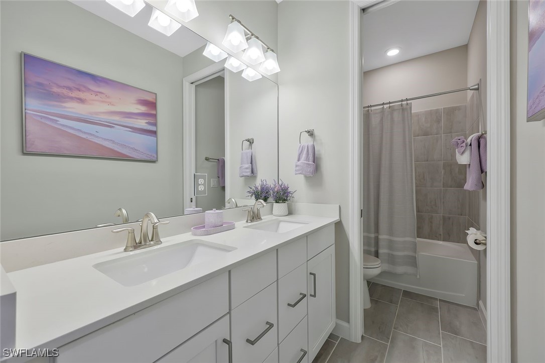 11697 Canopy Loop Fort Myers, FL 33913 - Photo 23 of 50 a bathroom with a sink a toilet a large mirror and shower