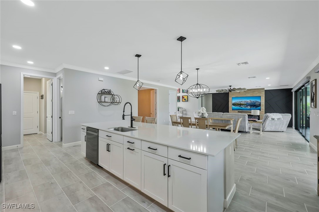 11697 Canopy Loop Fort Myers, FL 33913 - Photo 9 of 50 a large kitchen with kitchen island a counter space a sink appliances and a living room view