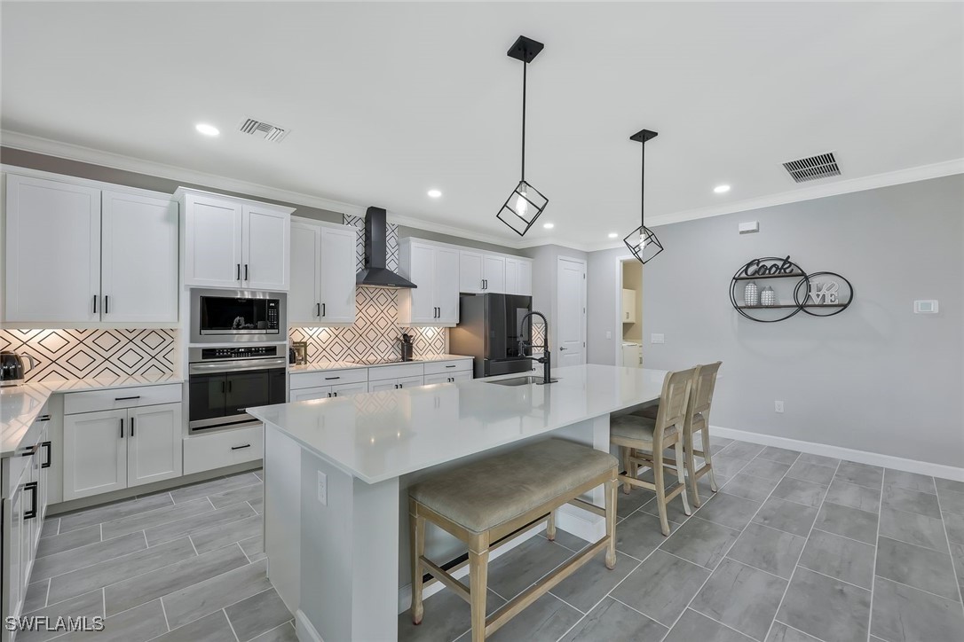 11697 Canopy Loop Fort Myers, FL 33913 - Photo 10 of 50 a view of a kitchen with kitchen island granite countertop stainless steel appliances cabinets a sink and a counter top space