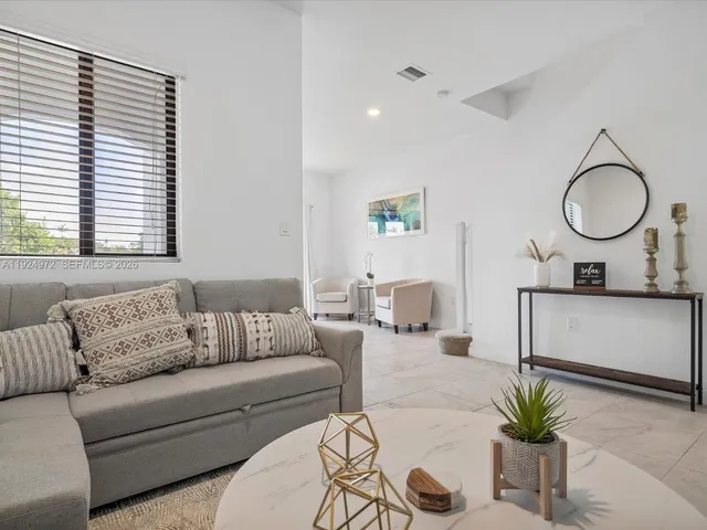 a living room with furniture and a potted plant