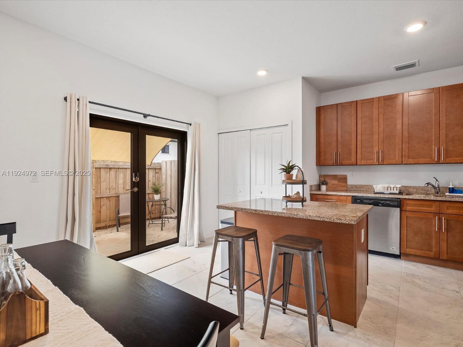 13344 Southwest 250th Street Homestead, FL 33032 - Photo 4 of 20 a kitchen with stainless steel appliances granite countertop a stove a refrigerator a sink a dining table and chairs with wooden floor