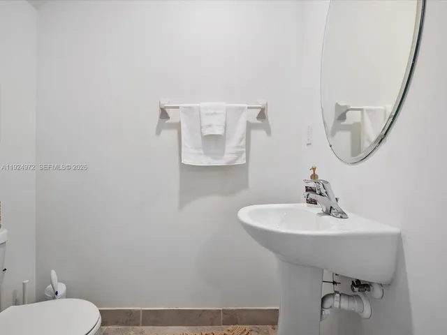 a bathroom with a sink a toilet and mirror