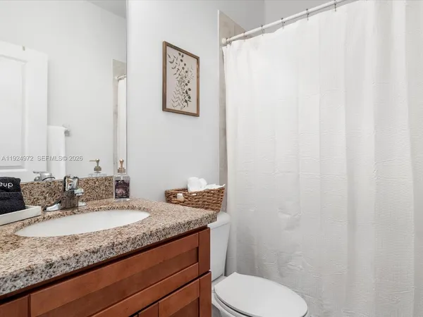a bathroom with a granite countertop sink and a mirror