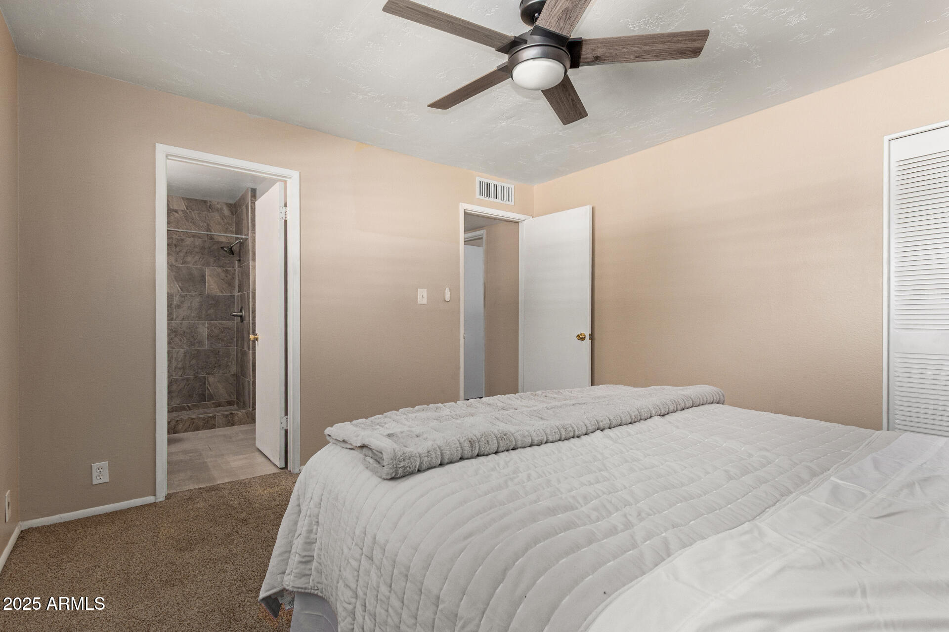 1320 East Bethany Home Road, Unit 54 Phoenix, AZ 85014 - Photo 14 of 37 a bedroom with a large bed and a chandelier