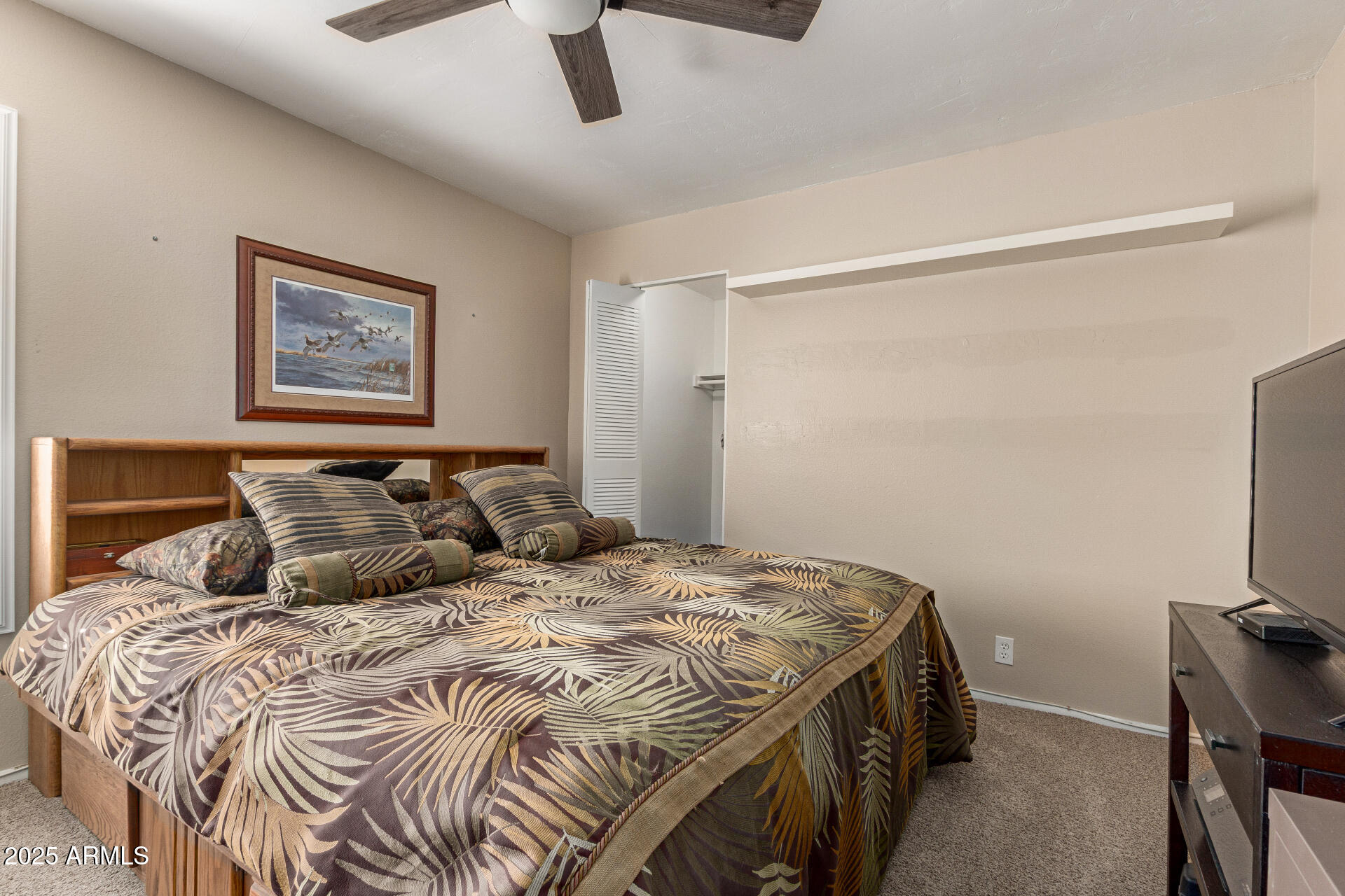 1320 East Bethany Home Road, Unit 54 Phoenix, AZ 85014 - Photo 17 of 37 a bedroom with a bed and a tv on a dresser
