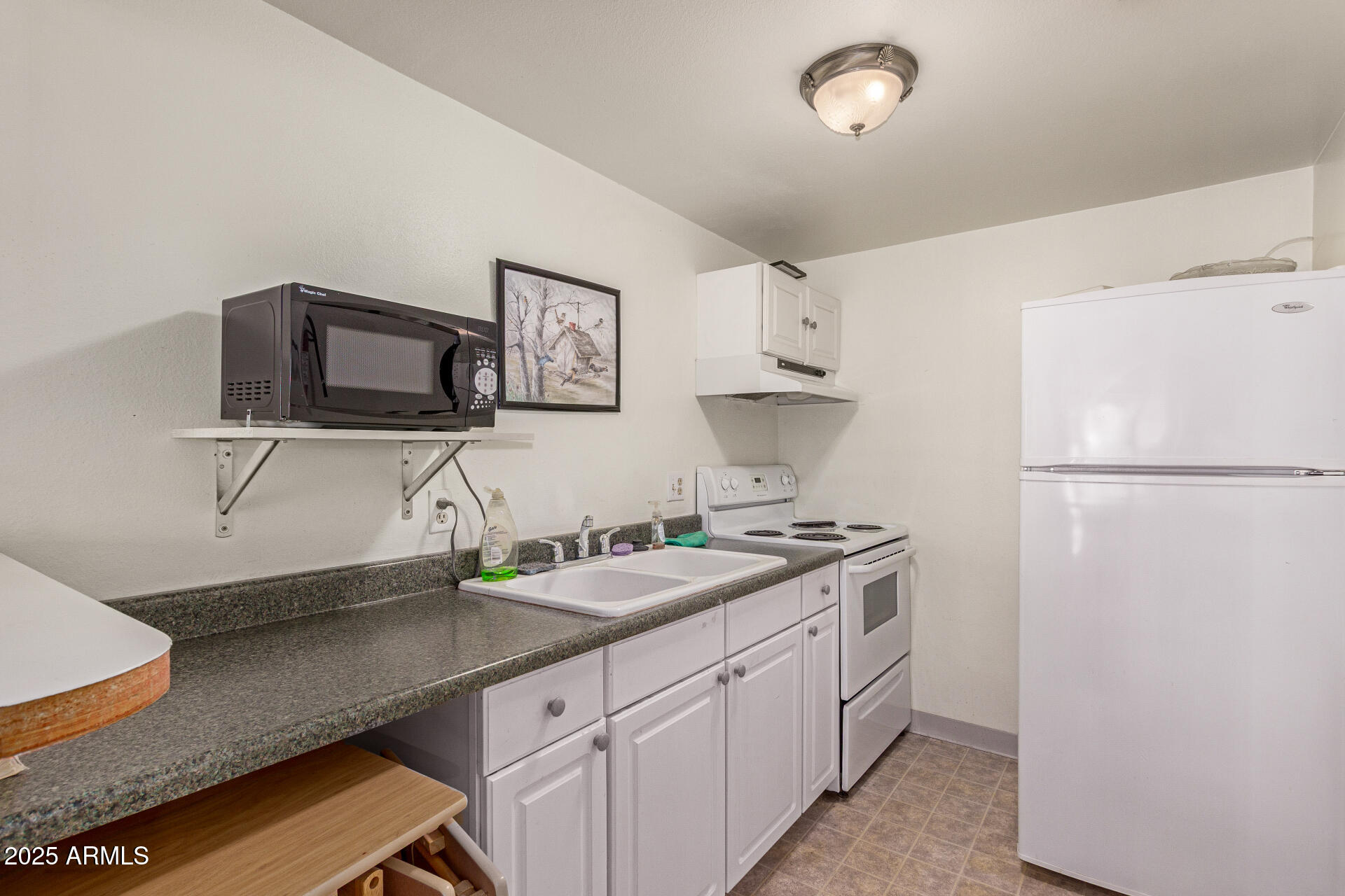1320 East Bethany Home Road, Unit 54 Phoenix, AZ 85014 - Photo 31 of 37 a kitchen with stainless steel appliances granite countertop a sink stove and refrigerator