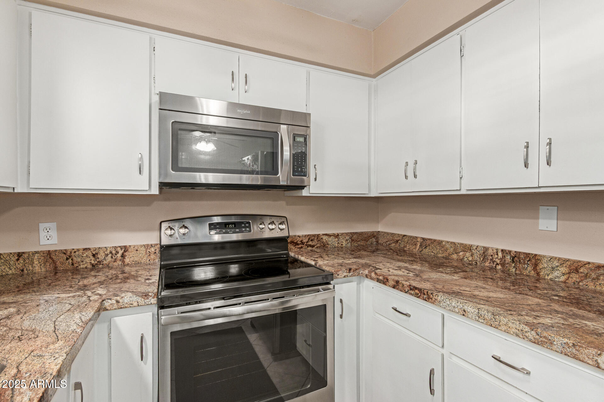 1320 East Bethany Home Road, Unit 54 Phoenix, AZ 85014 - Photo 9 of 37 a kitchen with granite countertop white cabinets and stainless steel appliances