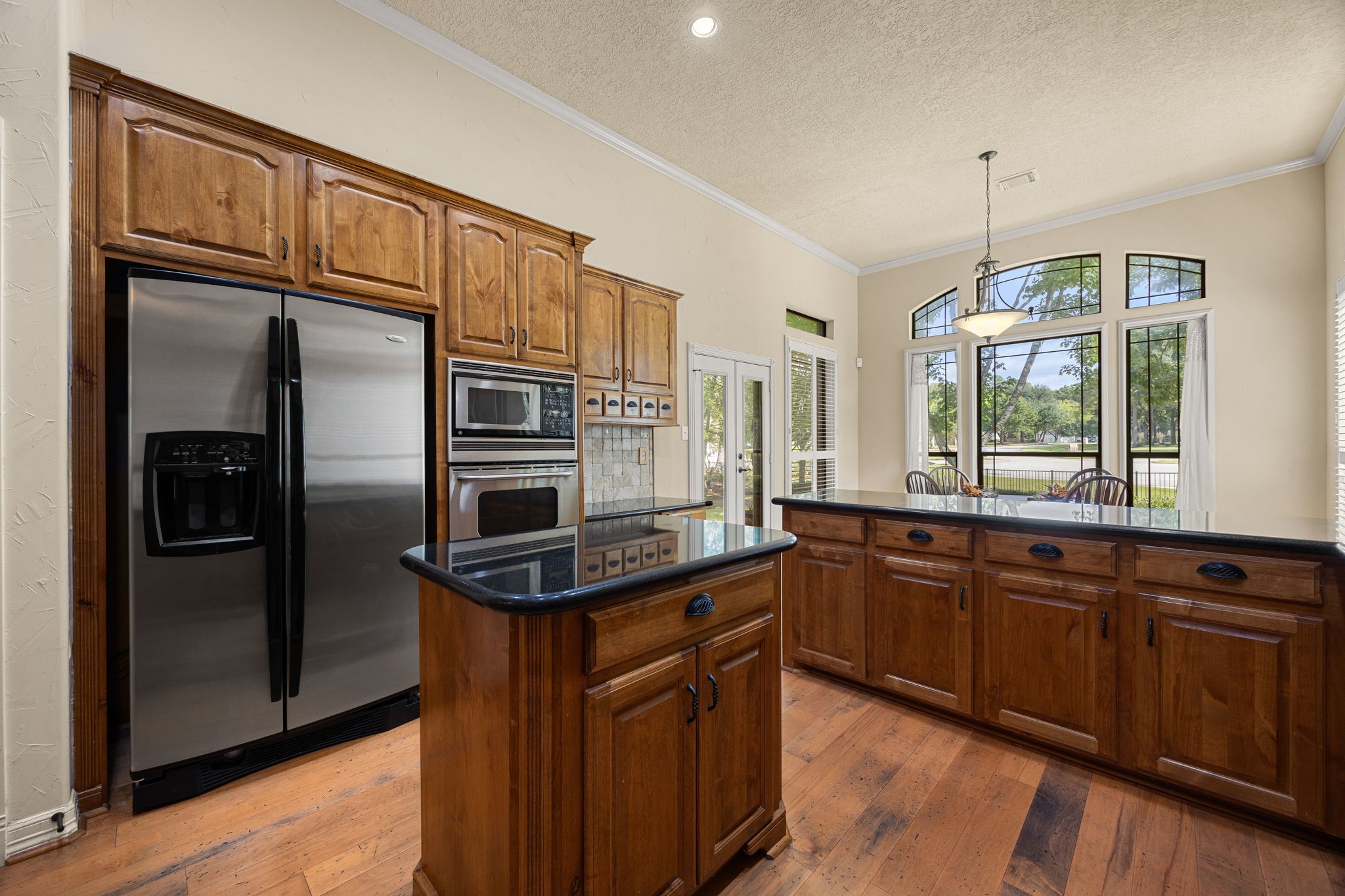 28618 Benders Crossing Drive Spring, TX 77386 - Photo 11 of 46 Spacious kitchen featuring a large center island, stainless steel refrigerator, and built-in microwave. Abundant cabinetry and generous counter space provide both functionality and storage for everyday living.