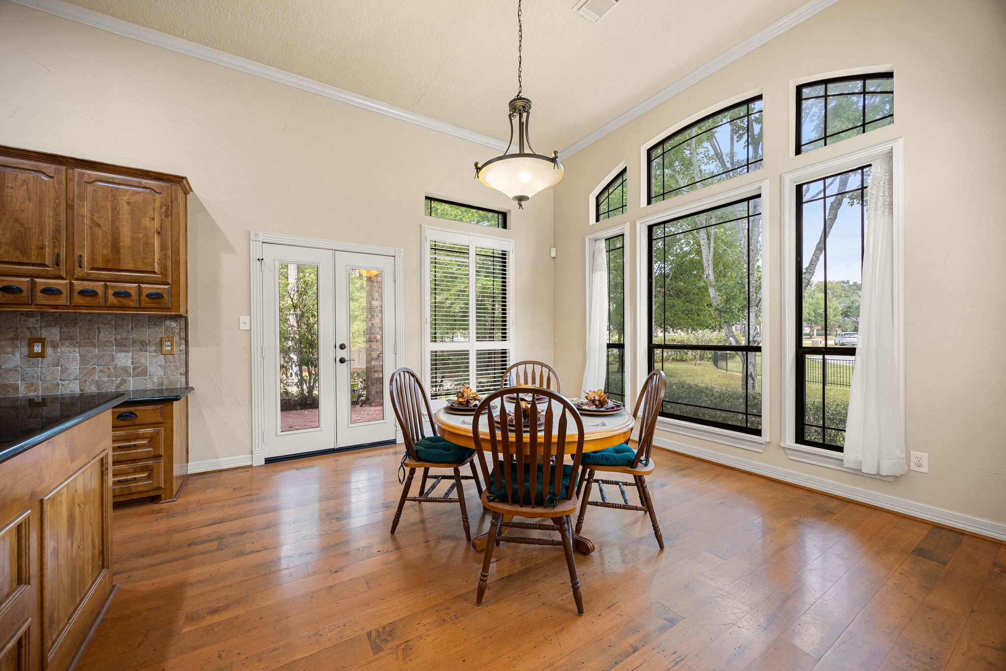 28618 Benders Crossing Drive Spring, TX 77386 - Photo 13 of 46 Light-filled breakfast area with large windows and French doors providing views of the backyard and direct access to the outdoor living space. Natural light and serene surroundings enhance everyday comfort.