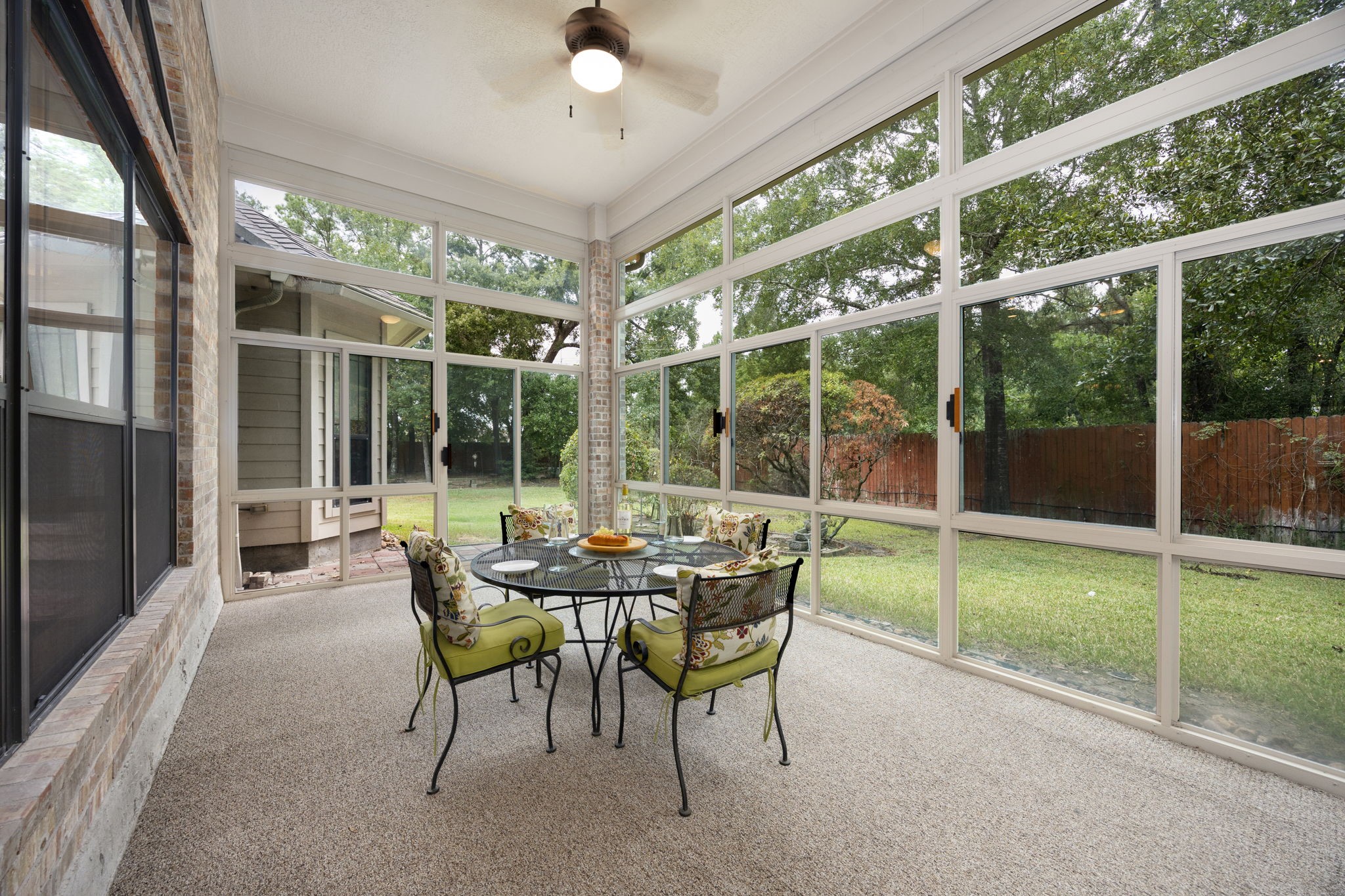 28618 Benders Crossing Drive Spring, TX 77386 - Photo 27 of 46 Inviting enclosed sunroom featuring expansive windows, ceiling fan, and serene views of the backyard. A versatile space ideal for year-round enjoyment, casual dining, or relaxing while surrounded by natural light.