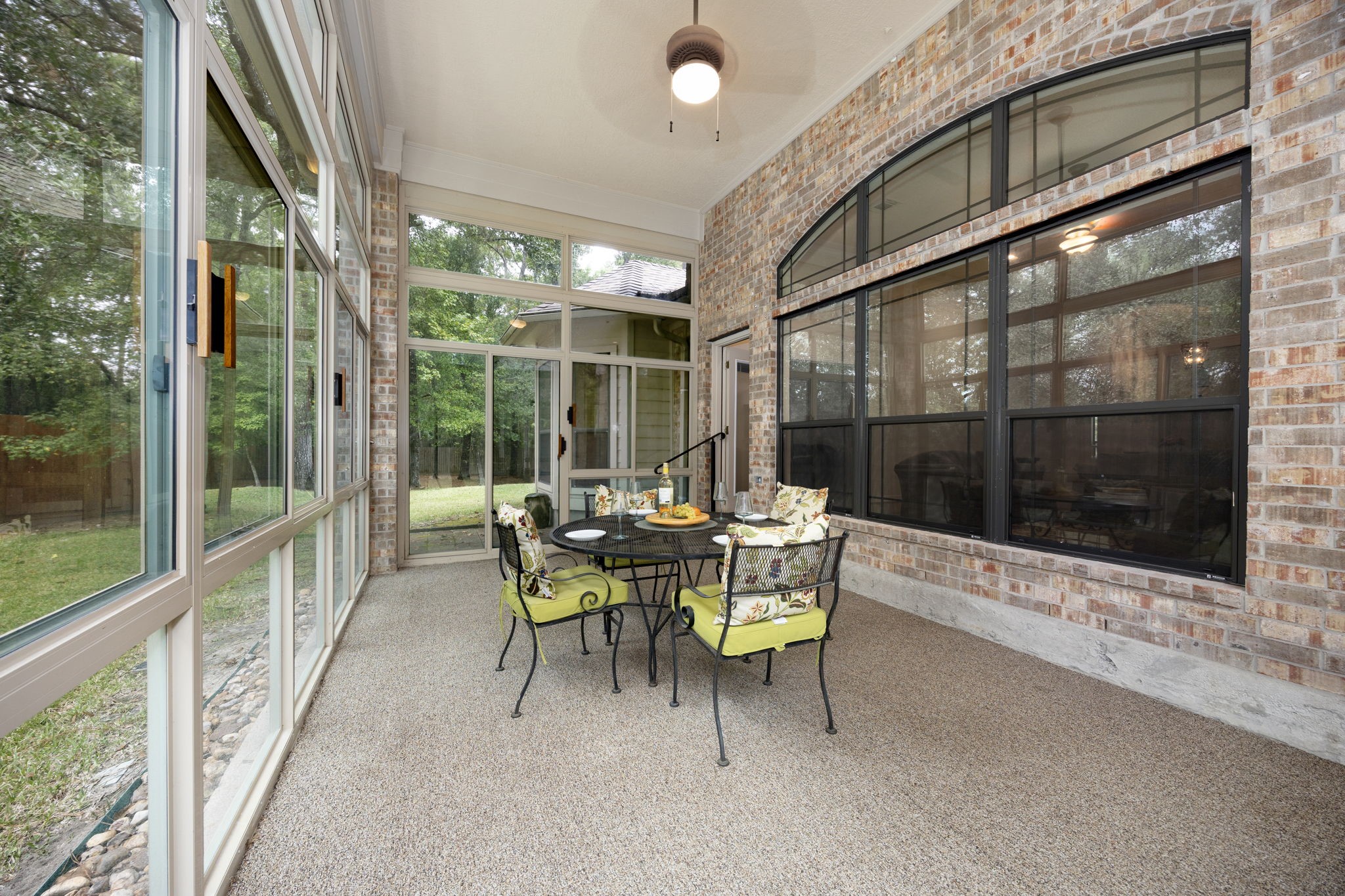 28618 Benders Crossing Drive Spring, TX 77386 - Photo 28 of 46 Spacious sunroom showcasing wall-to-wall windows, durable flooring, and seamless indoor-outdoor connection. Perfect for entertaining or unwinding while enjoying peaceful backyard scenery.