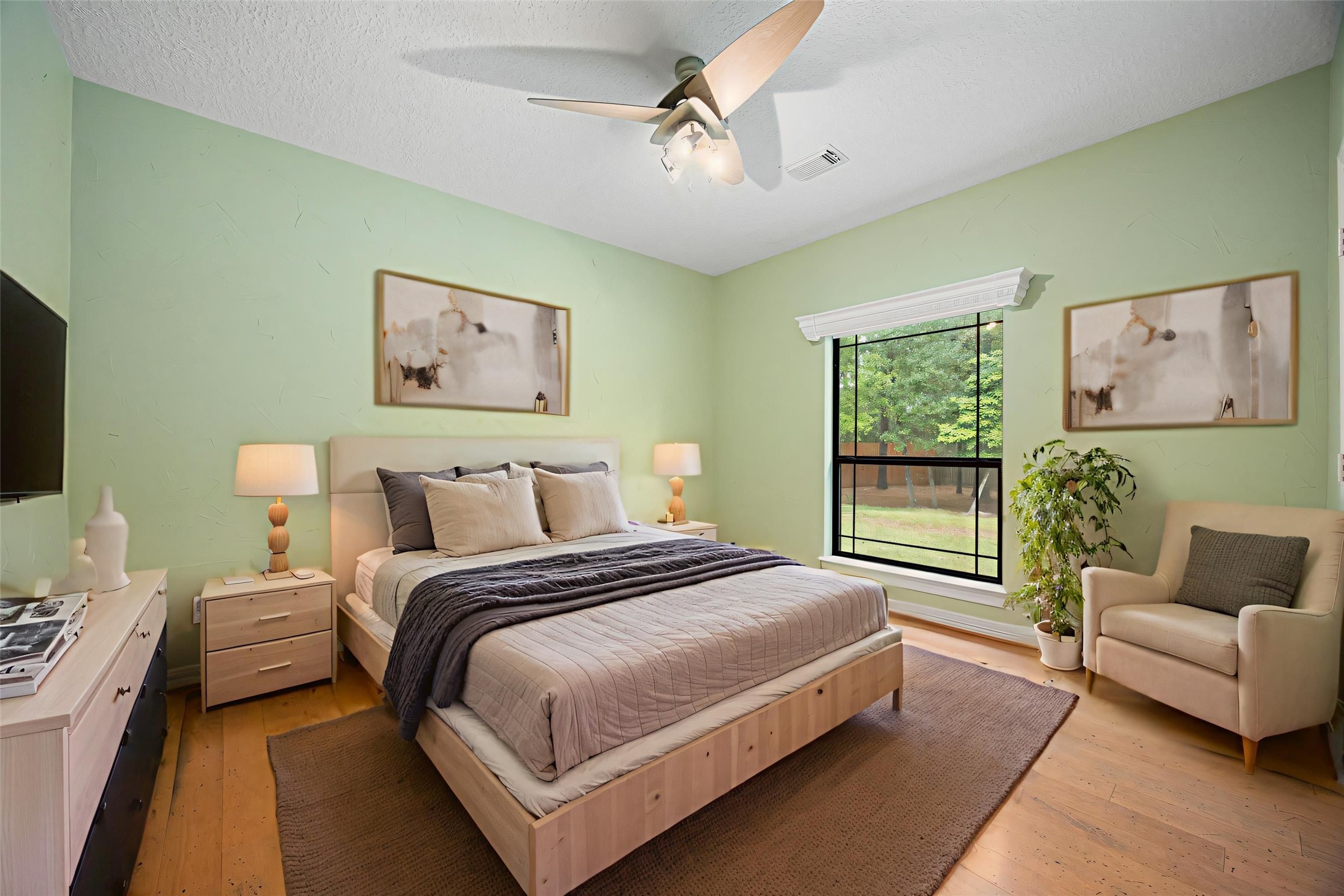 28618 Benders Crossing Drive Spring, TX 77386 - Photo 33 of 46 Spacious secondary bedroom with hardwood flooring, ceiling fan, and large window overlooking the backyard. Soft, neutral tones and abundant natural light create a relaxing retreat.