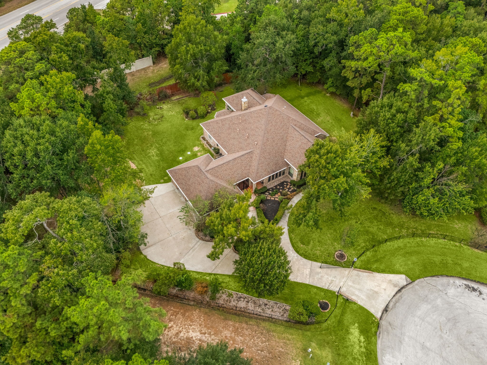28618 Benders Crossing Drive Spring, TX 77386 - Photo 41 of 46 Aerial view highlighting the home’s expansive lot, circular driveway, and surrounding mature trees, offering privacy and a peaceful setting within an established neighborhood.