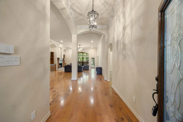 a view of a hallway with wooden floor and staircase