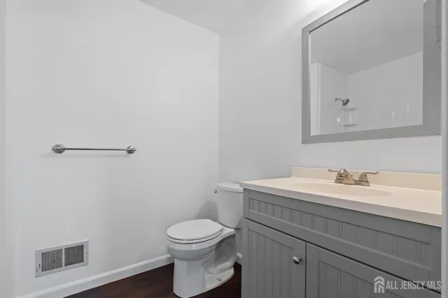 a bathroom with a toilet sink vanity and mirror