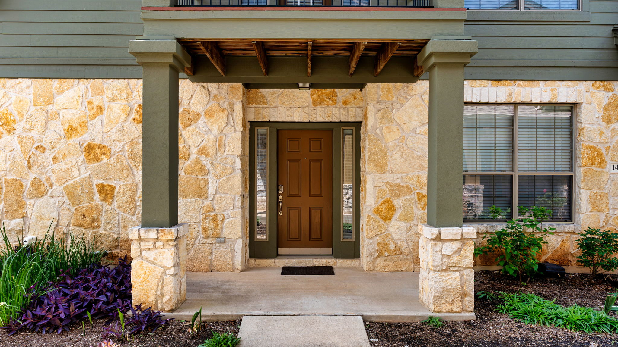 14815 Avery Ranch Boulevard, Unit 1401 Austin, TX 78717 - Photo 3 of 38 Stone veneer exterior featuring a wood-panel entry door with sidelights