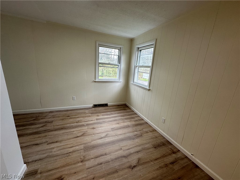 119 Shields Road, Unit 3 Youngstown, OH 44512 - Photo 2 of 12 Empty room featuring wood finished floors and a textured ceiling