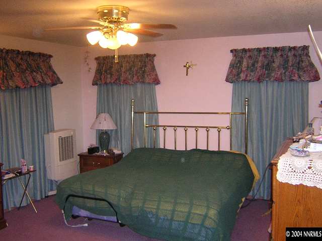 10101 Osage Road Reno, NV 89508 - Photo 7 of 9 a bed sitting in a bedroom next to a window and a chandelier