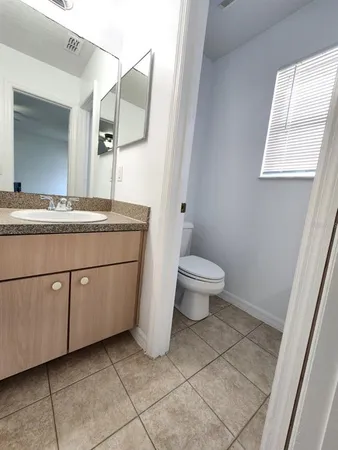 a spacious bathroom with a granite countertop toilet a sink and a mirror