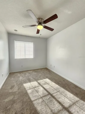 a view of a room with a ceiling fan and a window